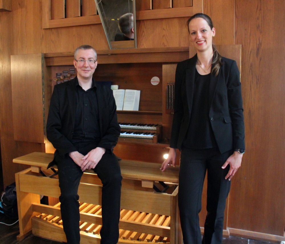 Zwei Personen vor einer Orgel