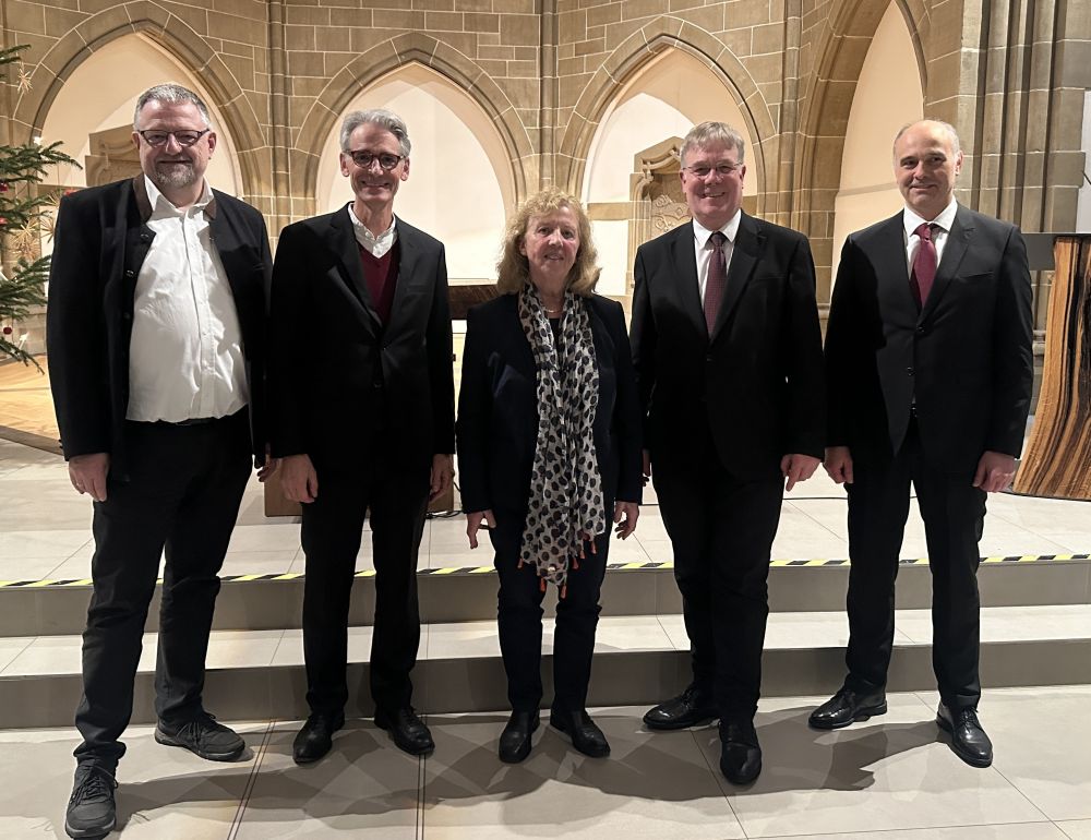 Fünf Personen stehen vor den Altar